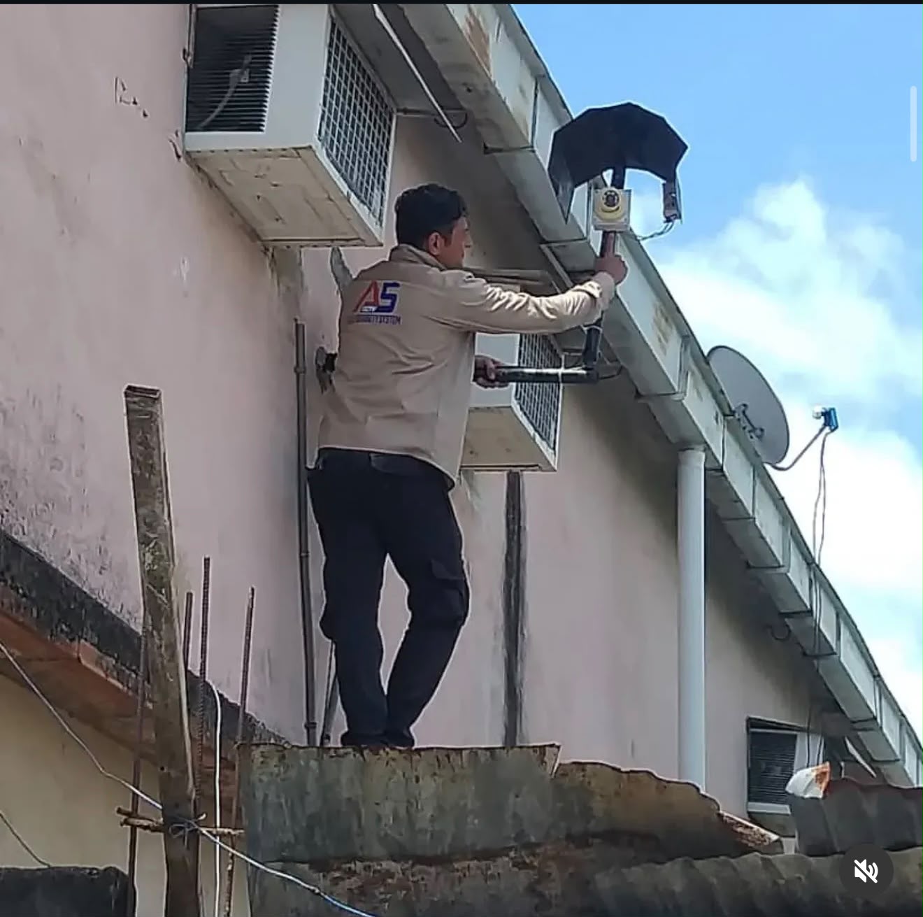 Técnico de Alex Security System instalando cámara exterior en fachada de edificio