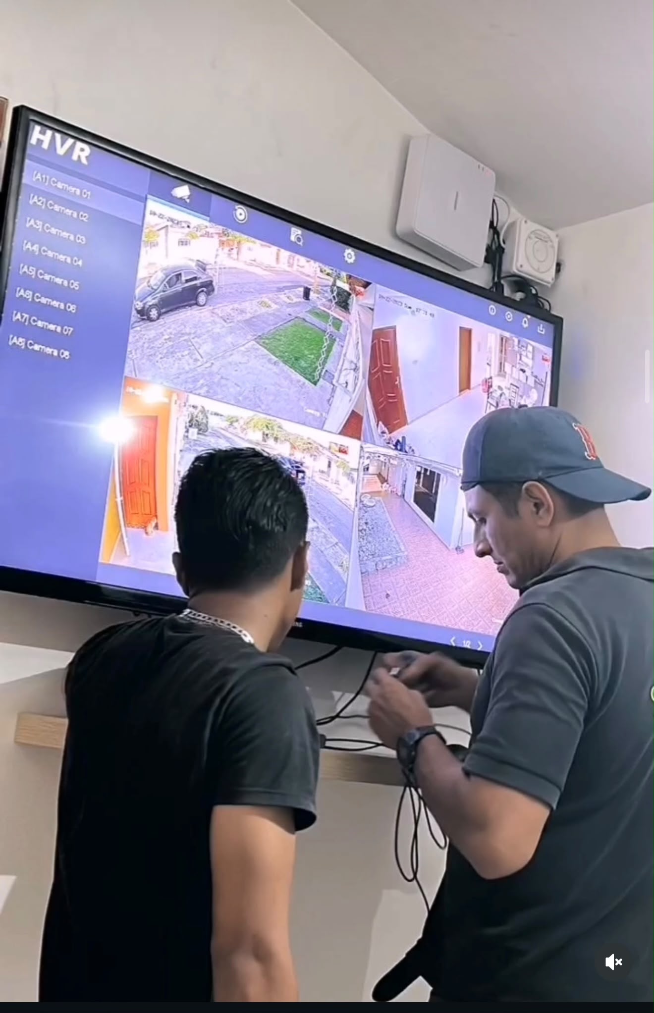 Técnicos configurando grabador HVR con el cliente — sistema de 8 cámaras residencial